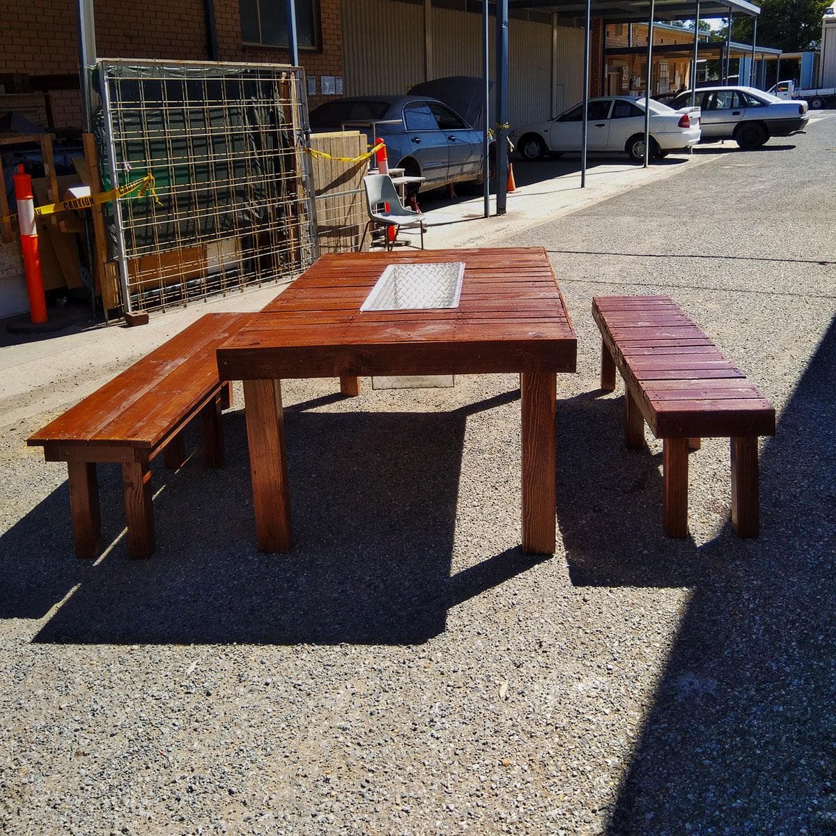 Wooden outdoor dining set with two benches and table with glass inlay